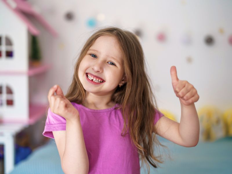 Cô gái nhỏ tươi cười với hàm răng thiếu chiếc răng cửa