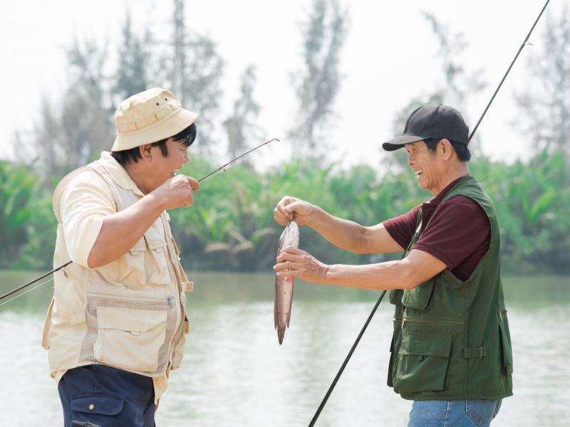hai người đàn ông mừng rỡ vì bắt được cá