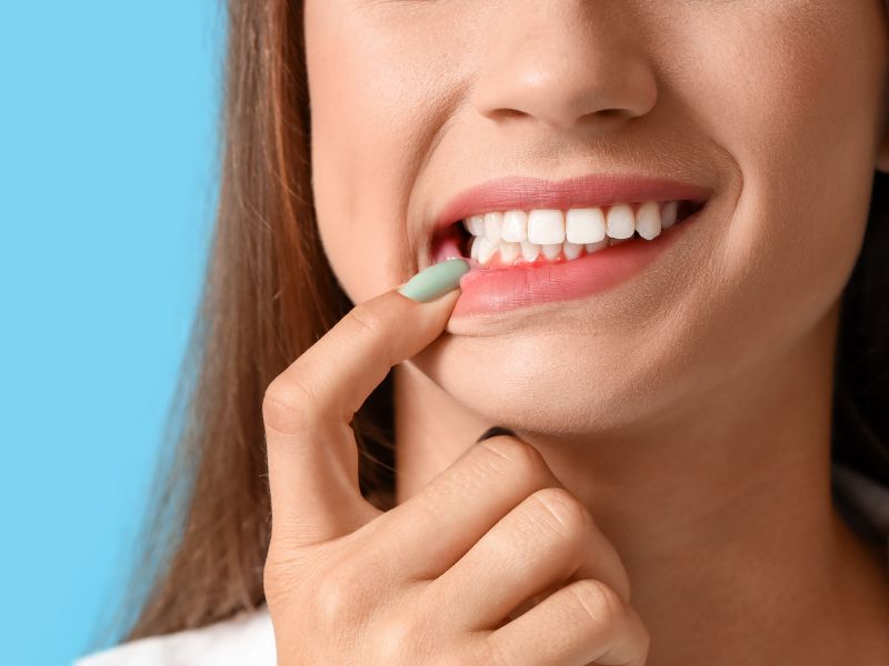 Người phụ nữ đang dùng tay kiểm tra răng