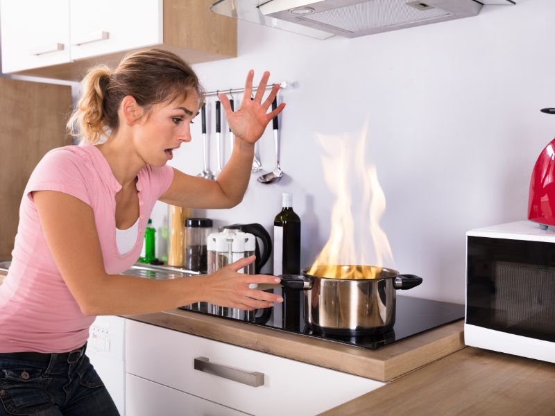 người phụ nữ hoảng hốt vì cháy trên bếp