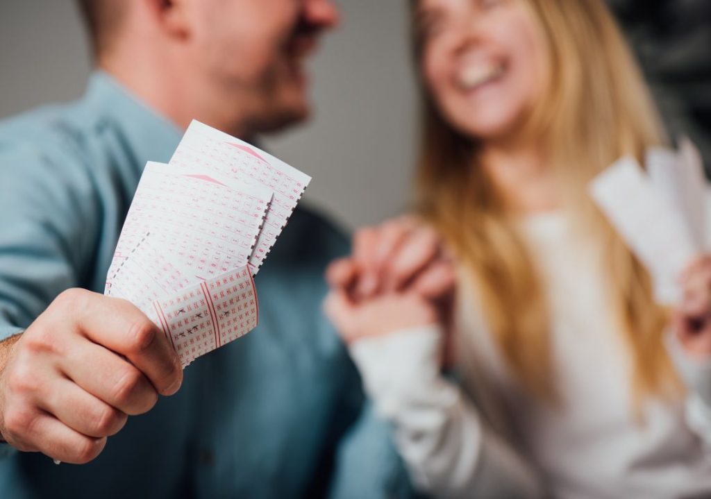 hai người cầm vé số vui vẻ