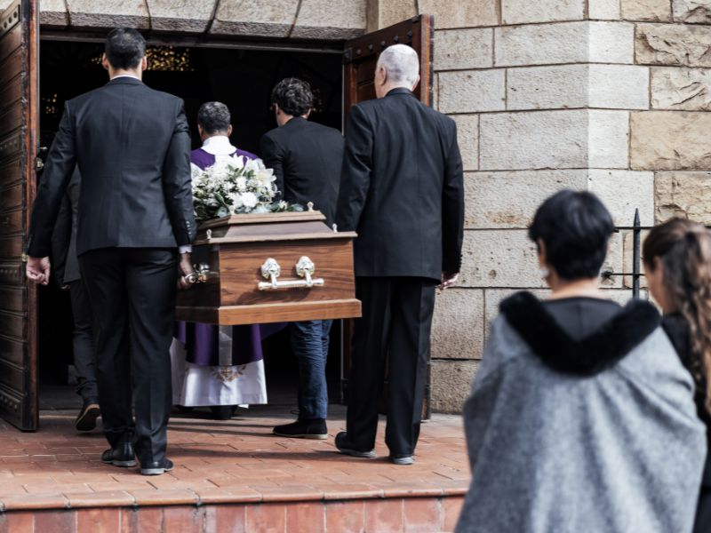 Nhiều người đang mang quan tài vào trong nhà thờ