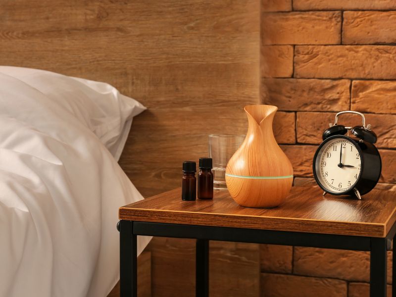 tinh dầu và máy khuếch tán trên bàn đầu giường