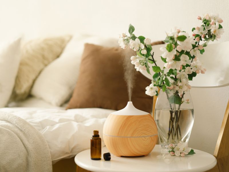 máy khuếch tán tinh dầu và hoa trên bàn đầu giường