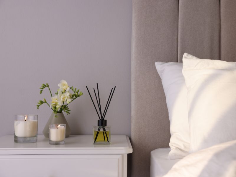 nến thơm và tinh dầu trên kệ đầu giường