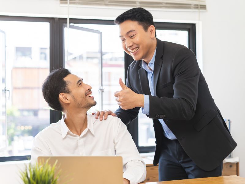 hai nam đồng nghiệp đang cổ vũ giúp đỡ nhau